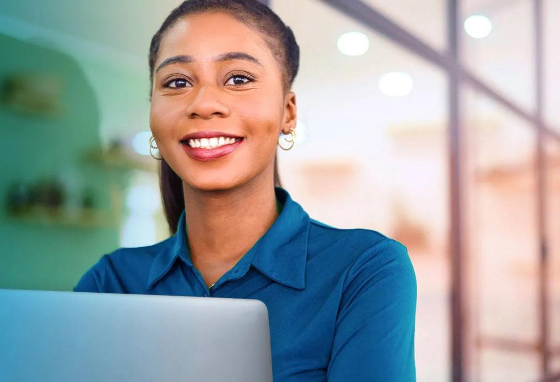 A woman smiles while working at a computer