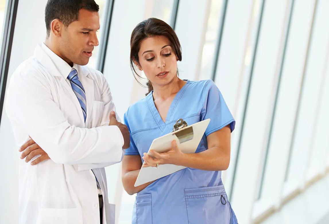 Two medical professionals review a document