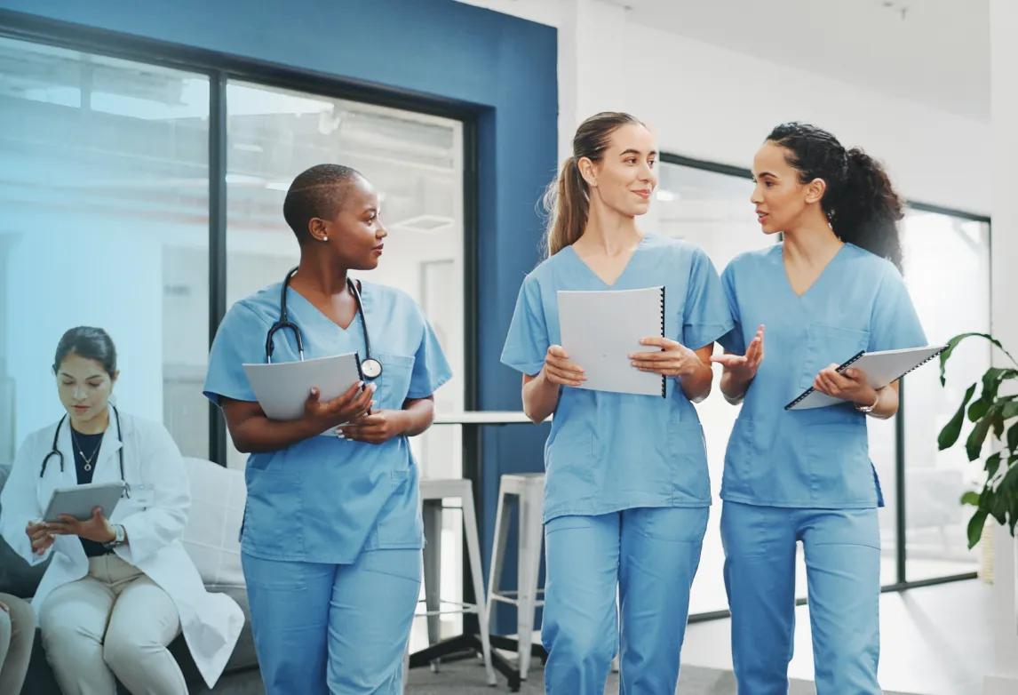 three healthcare staff talking to each other