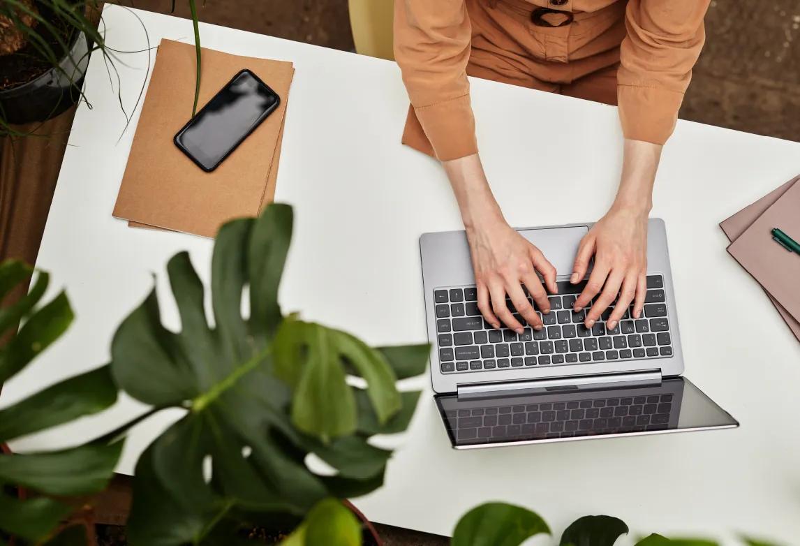 person using a laptop and tablet to find a new job