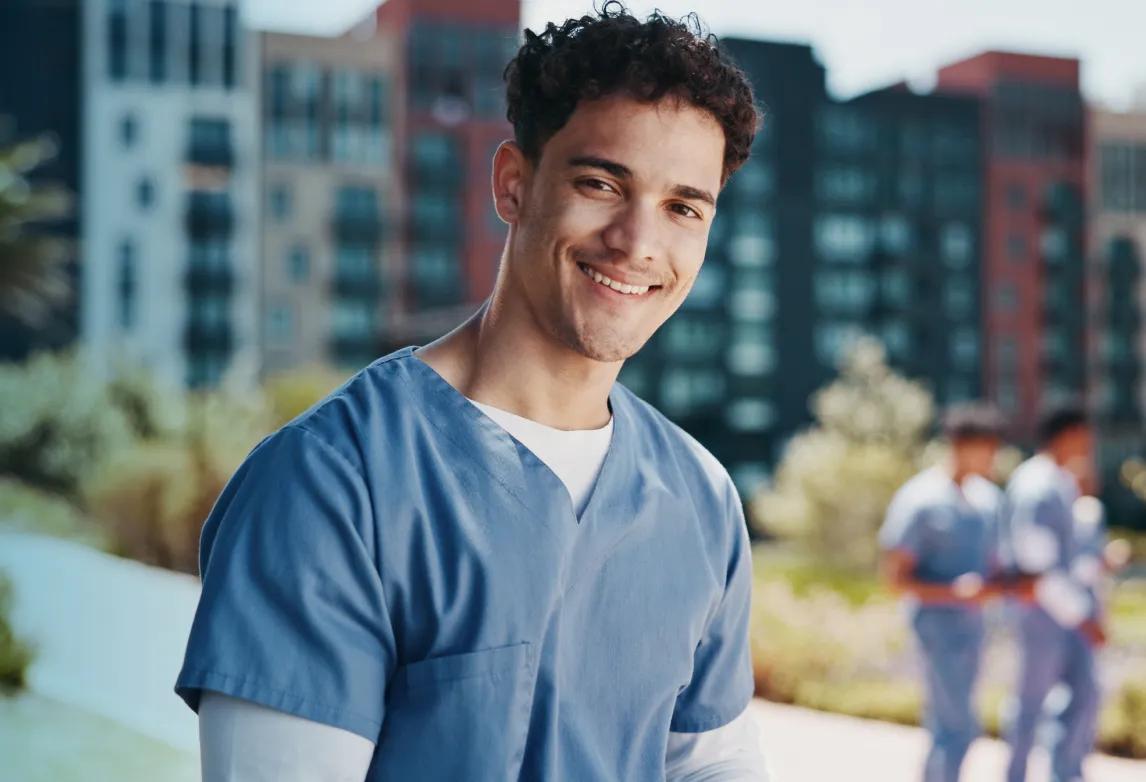 healthcare worker standing and smiling because he has a career matching his learning style